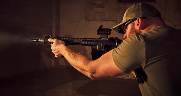 Man holding an AR-15 using Contour Tactic’s F.O.G. (forward operational grip) to aim with precision and comfort.