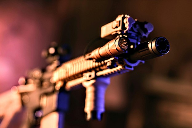 A closeup of a rifle with an assortment of precision firearm gear.